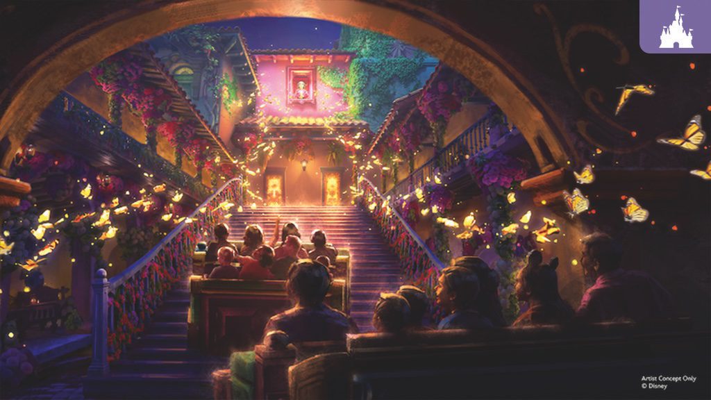 Visitors seated in ride vehicles pass under a stone arch into a flower-adorned courtyard with glowing butterflies and a grand staircase
