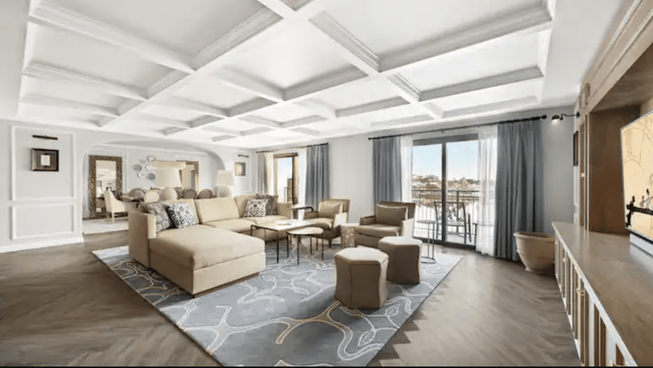 Spacious, modern living area with a large couch, stylish seating, and large windows offering natural light and a view.