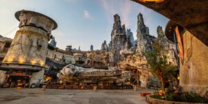 A landscape featuring towering rock formations, a futuristic structure, and a spacecraft in a vibrant, themed setting.
