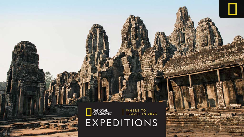 Ancient stone temples with towering spires, set against a clear sky, feature an overlay with National Geographic Expeditions branding.