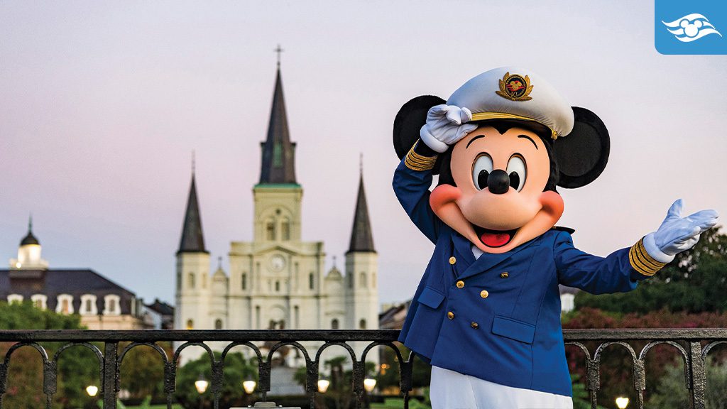 DCL New Orleans after a cruise Mickey Mouse, dressed as a captain, salutes in front of a historic building with spires at sunset.