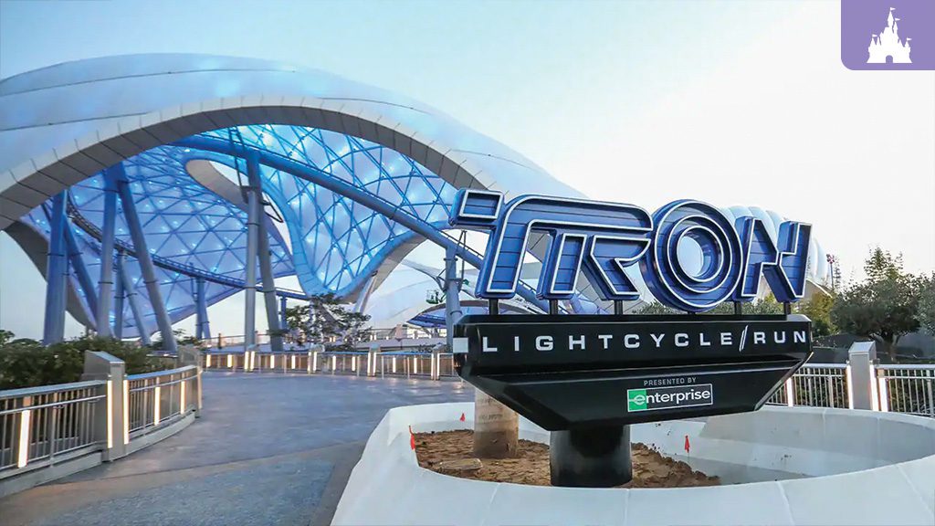 TRON Lightcycle The image shows the entrance sign for the TRON Lightcycle Run attraction, featuring a sleek blue structure in the background.