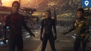 Three superheroes stand together in a futuristic setting, with a vibrant cosmic background and advanced structures around them.