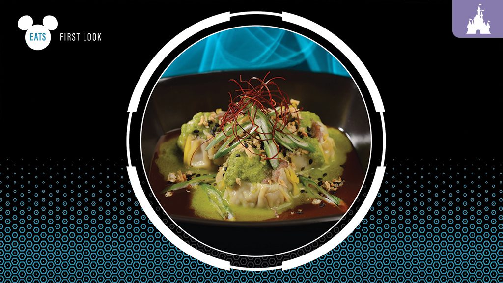 A close-up of artistic culinary dish featuring green sauce, garnishes, and red threads on a black plate against a vibrant background.