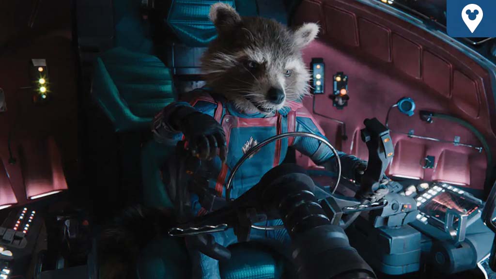 A raccoon in a spacesuit sits in a control room, interacting with a complex set of colorful buttons and screens.