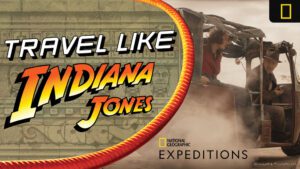 An adventurous scene with a vehicle in motion, featuring the text "Travel Like Indiana Jones" and the National Geographic logo.