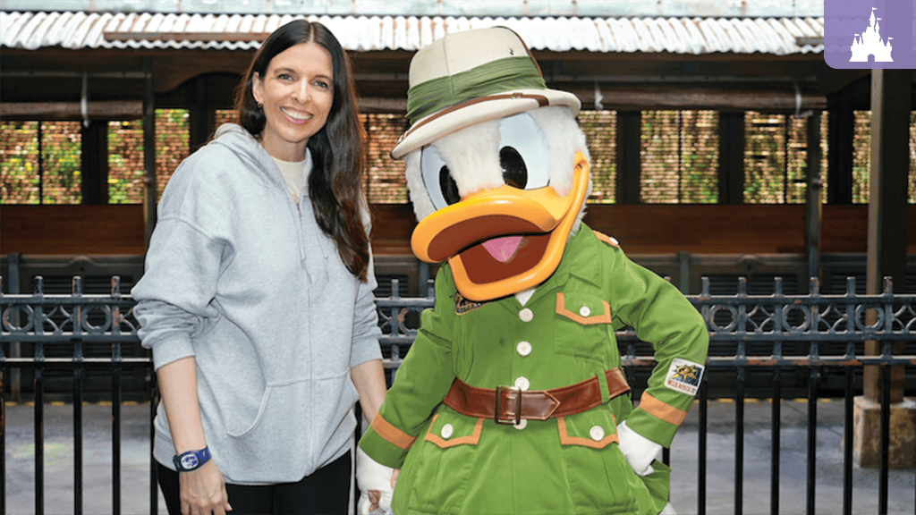 Guest smiling beside Donald Duck in safari outfit at Disney's Animal Kingdom Theme Park