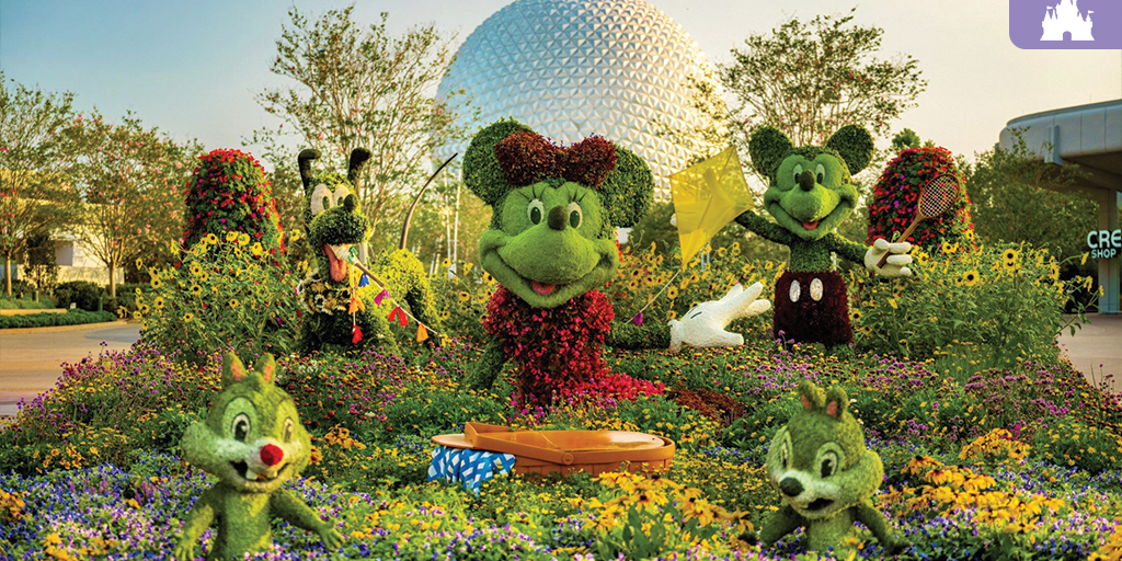 Topiary sculptures of cartoon mice (female with bow, male with racket), a dog, and two chipmunks amid flower beds with a geodesic dome behind