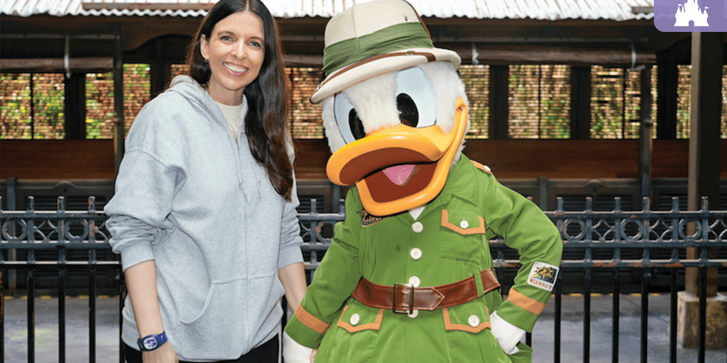 Guest smiling beside Donald Duck in safari outfit at Disney's Animal Kingdom Theme Park
