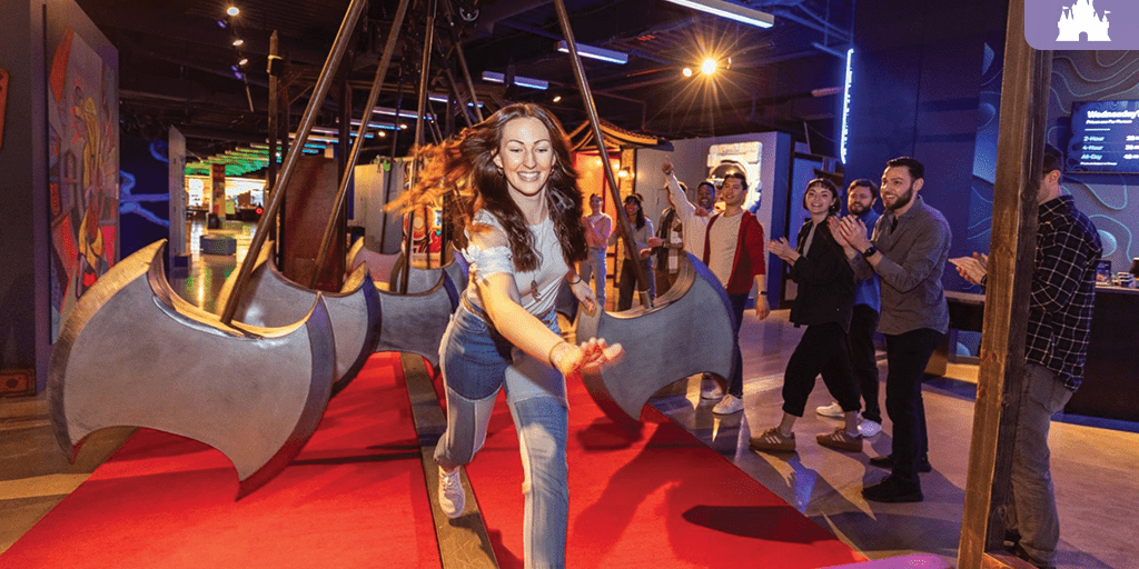 Claude responded: Woman dodging swinging axe obstacles at Level99 Disney Springs, an immersive adult gaming venue with colorful art installationsWoman dodging swinging axe obstacles at Level99 Disney Springs, an immersive adult gaming venue with colorful art installations