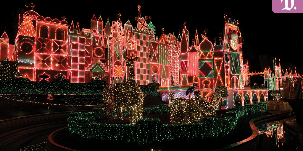 "it's a small world" Holiday facade lit up at night with colorful string lights, topiary reindeer, and festive decor at Disneyland