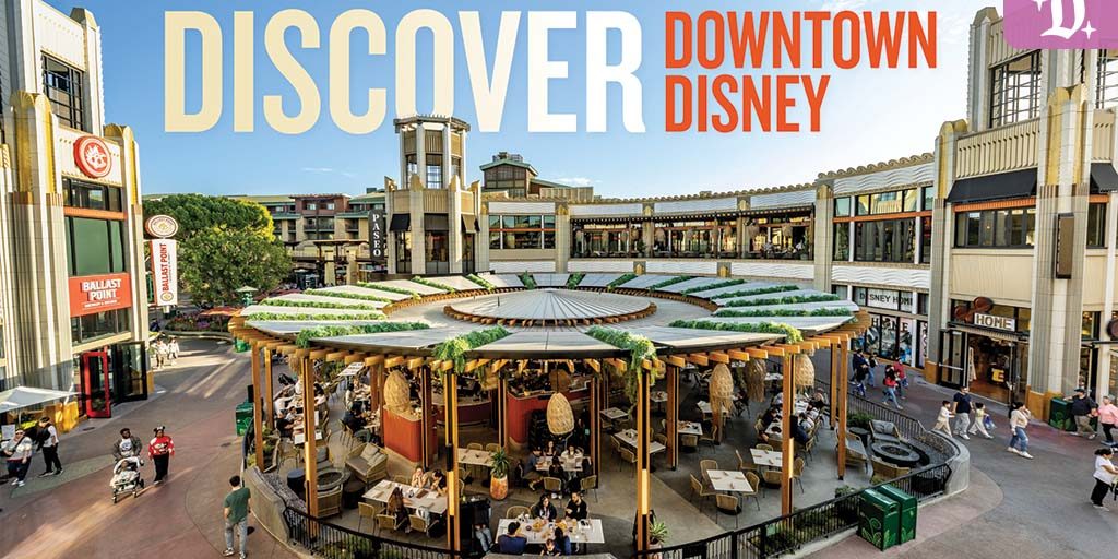 Open-air dining pavilion with wood pillars and hanging decor in a sunlit plaza surrounded by multi-level shops and strolling visitors.