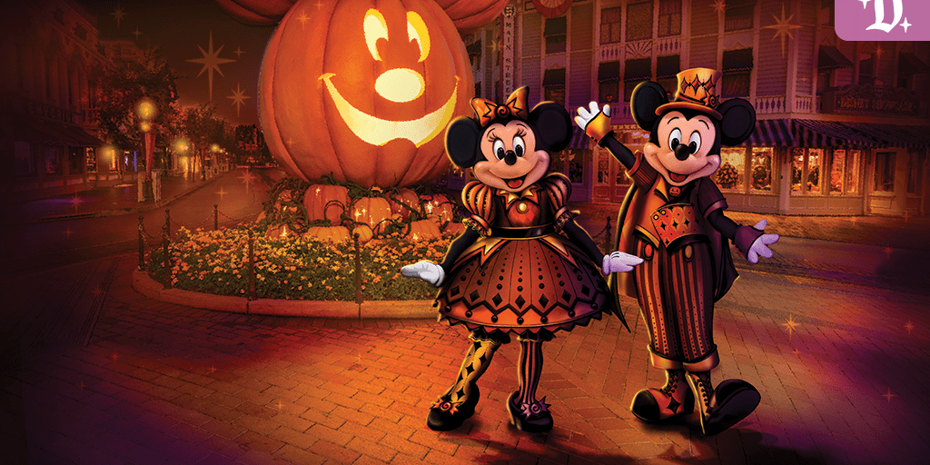 Mickey and Minnie Mouse in Halloween costumes on Main Street U.S.A. at Disneyland, with a giant glowing Mickey pumpkin behind them.