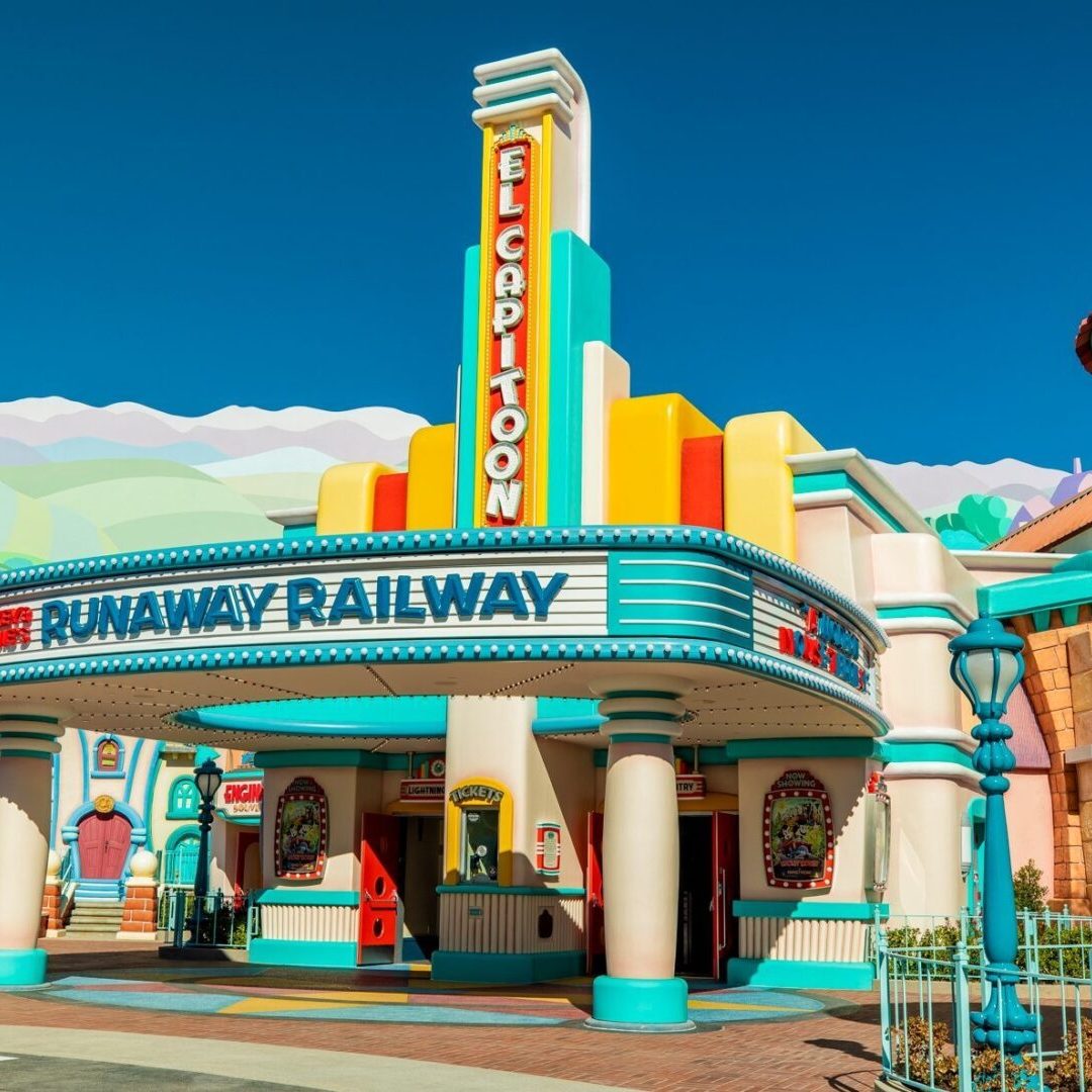 Brightly colored entrance to a theme park attraction called "Runaway Railway," featuring bold signage and whimsical architecture.