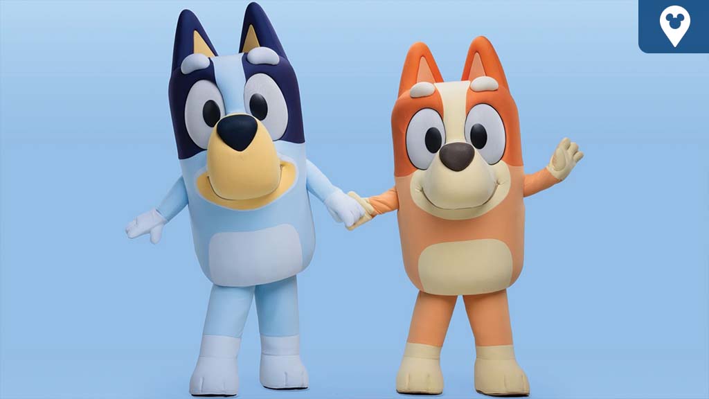 Bluey and Bingo characters holding hands and smiling against a light blue background.