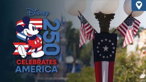 Mickey Mouse stands beside a patriotic "250 Celebrates America" logo, with U.S. flags and colonial bunting decorating a lamp post in a Disney park.