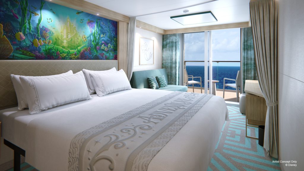 Deluxe oceanview stateroom on a Disney Cruise Line ship with large bed, seating area, and private verandah overlooking the sea.
