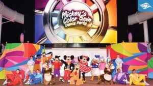 A vibrant stage displays "Mickey's Color Spin Dance Party" with Disney characters and performers posing in colorful costumes.