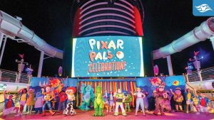 Pixar characters perform on a Disney Cruise ship deck during the vibrant Pixar Pals Celebration at night.