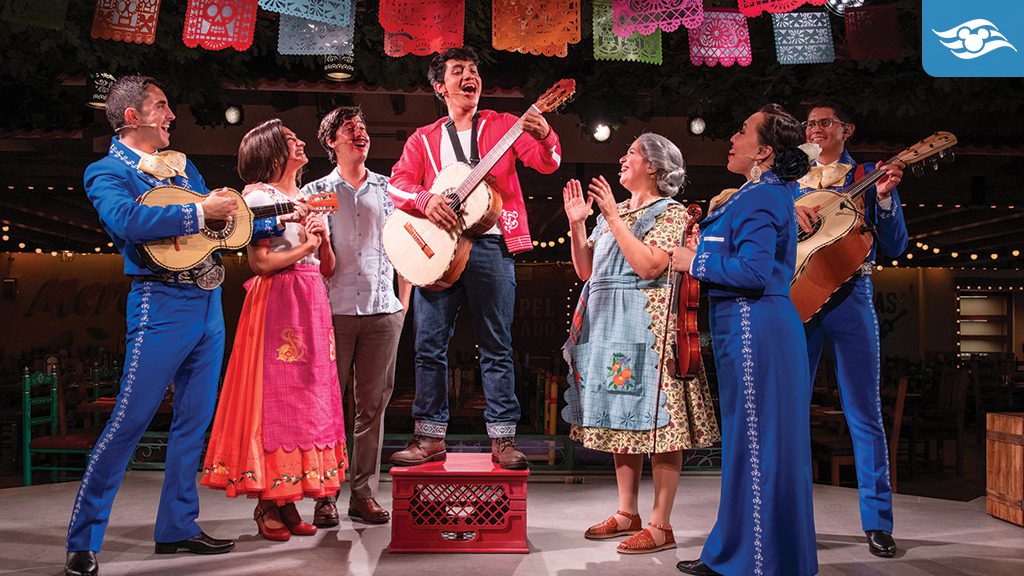 Miguel from Pixar's Coco performs on stage at Plaza de Coco aboard the Disney Treasure, surrounded by mariachi musicians, vibrant papel picado decorations, and family members from the Rivera household.