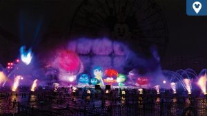 A vibrant night scene featuring colorful water projections and lights, with mist creating a magical atmosphere near a large ferris wheel.