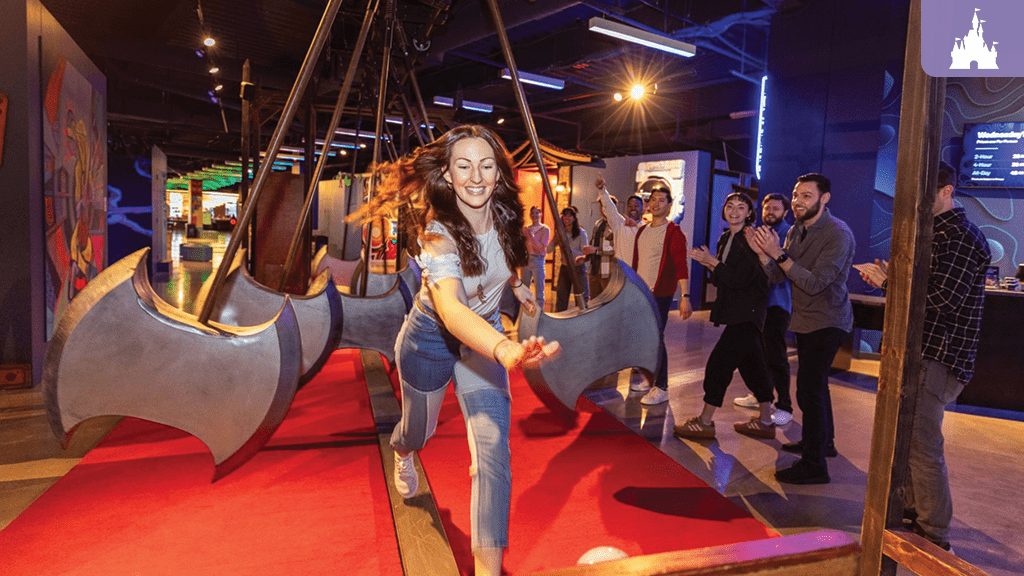 Claude responded: Woman dodging swinging axe obstacles at Level99 Disney Springs, an immersive adult gaming venue with colorful art installationsWoman dodging swinging axe obstacles at Level99 Disney Springs, an immersive adult gaming venue with colorful art installations
