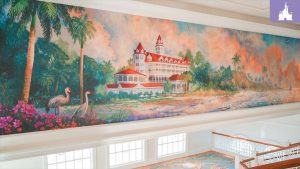 Impressionist-style mural of Disney’s Grand Floridian Resort with palm trees, cranes, and a colorful tropical landscape.