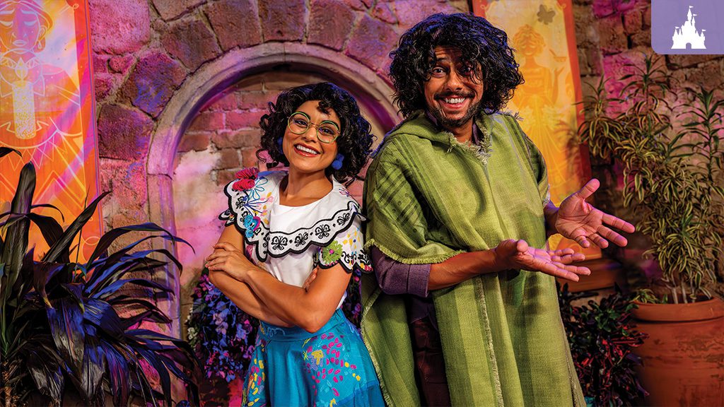Mirabel and Bruno from Encanto posing together in colorful costumes at a themed character meet-and-greet spot at Walt Disney World.
