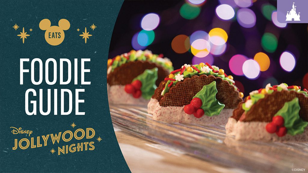 Festive holiday-themed cookies shaped like tacos, decorated with holly and colorful sprinkles, displayed in a row with glowing holiday lights in the background.