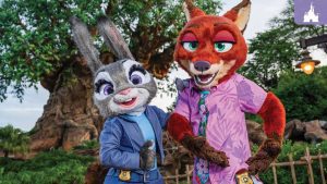 Judy Hopps and Nick Wilde pose in front of the Tree of Life at Disney’s Animal Kingdom, wearing their updated outfits from Zootopia 2.