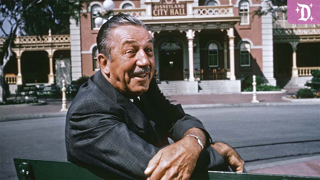 disneyland-70th-anniversary-new-main-street-experiences Walt Disney sits on a bench at Disneyland, smiling with Disneyland City Hall in the background. The image captures the park's early charm and Walt's visionary spirit.