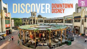 A vibrant aerial view of Downtown Disney District at Disneyland Resort, showcasing an open-air dining area with lush greenery, surrounded by shops and restaurants. The text "DISCOVER DOWNTOWN DISNEY" is prominently displayed at the top.