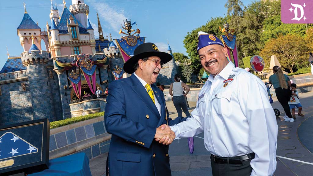 disneyland-honors-purple-heart A veteran shakes hands in front of Disneyland’s Sleeping Beauty Castle during a Purple Heart recognition event.
