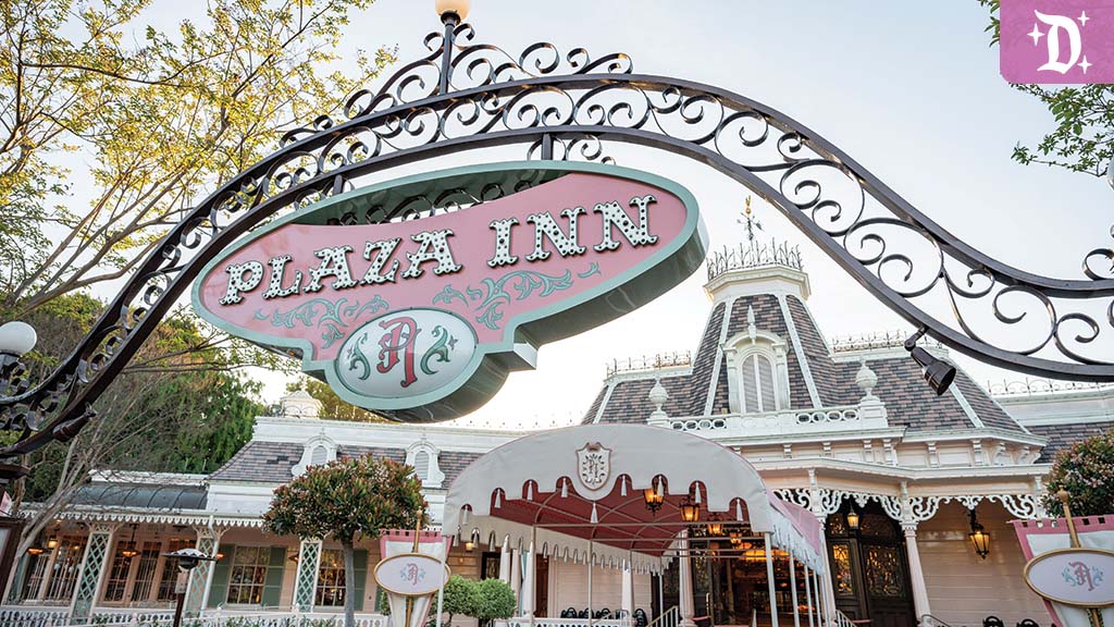 disneyland-new-dining-experiences Entrance sign for Plaza Inn at Disneyland, featuring ornate ironwork and a pink vintage-style sign with decorative lettering.
