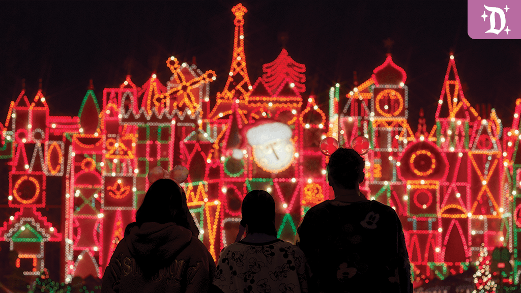 Three people stand with their backs to the camera, admiring a brightly lit display of colorful holiday lights against a dark background.