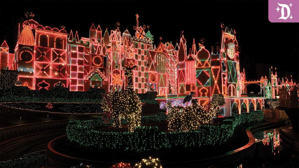 "it's a small world" Holiday facade lit up at night with colorful string lights, topiary reindeer, and festive decor at Disneyland
