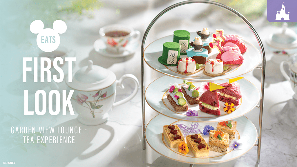 Three-tiered tray of Alice in Wonderland-themed afternoon tea treats at Garden View Lounge, with floral teacups and teapot in the background.