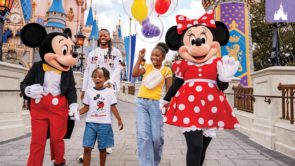 mickey-minnie-disney-world A smiling family walks with Mickey and Minnie Mouse at Walt Disney World, holding balloons in front of Cinderella Castle.