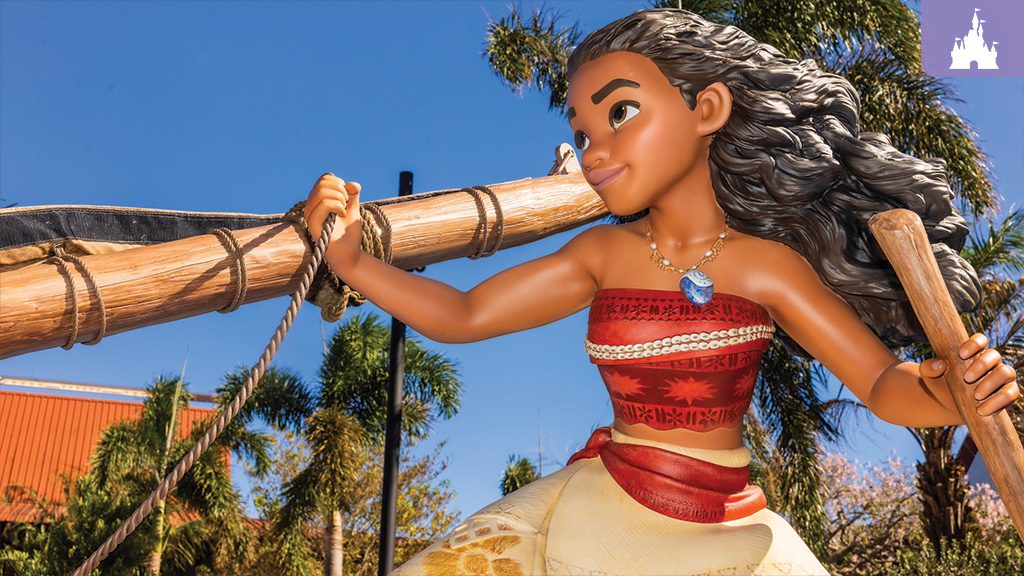 A life-size sculpture of Moana holding a canoe paddle, featured at the splash pad play area "Moana's Voyage" at Disney’s Polynesian Villas & Bungalows, with palm trees in the background.