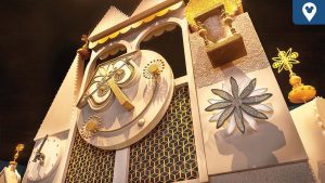 Close-up of the golden clock facade from Disney's “it’s a small world” attraction, featuring geometric patterns and whimsical flower designs.