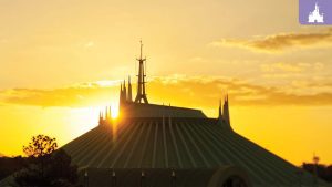 Space Mountain at Magic Kingdom silhouetted against a vibrant orange sunset, with the spires of the futuristic structure glowing in the fading light.