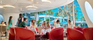 Families and friends gather at Moonrise Bar with drinks and snacks, with views of the pool and palm trees at Universal Terra Luna Resort.