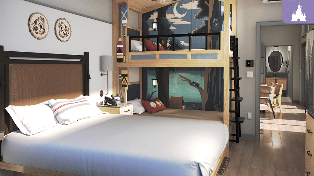 A cozy hotel room featuring a large bed and a colorful bunk bed with a forest mural, alongside a wooden dresser and a small dining area.