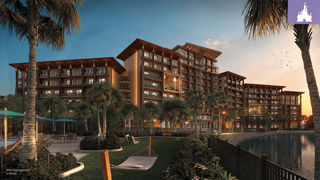 A modern resort building with a tropical landscape, palm trees, and a pool, illuminated by sunset glow near a calm water body.