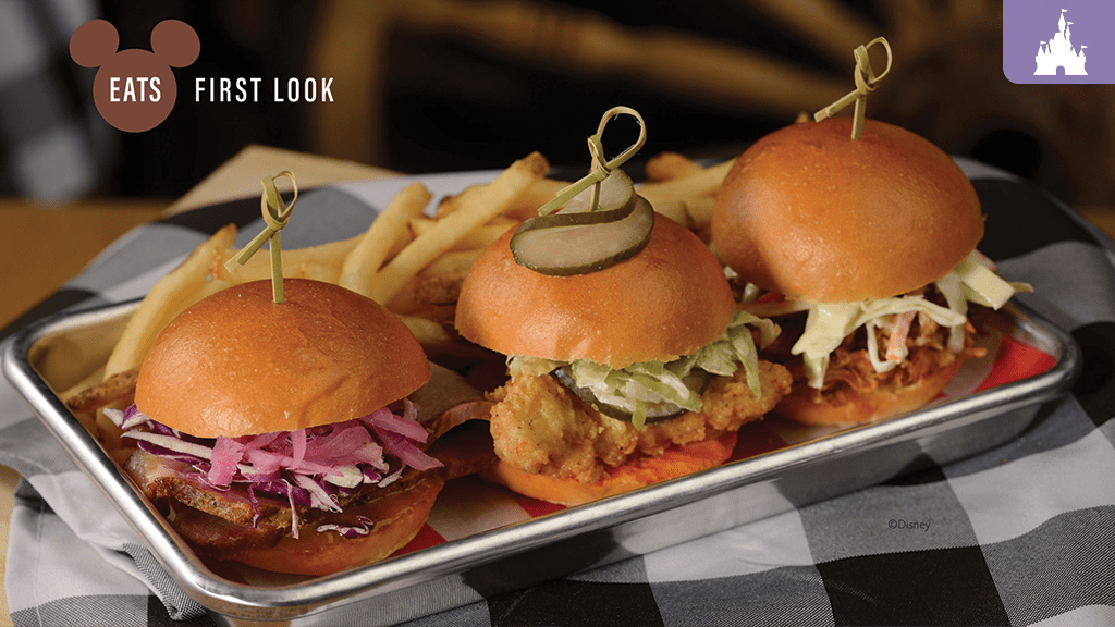 Three sliders with various toppings, served with French fries on a checkered tablecloth. A logo indicating "Eats First Look" is in the corner.